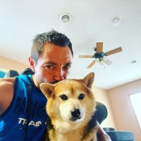 Man in vest taking a selfie with dog